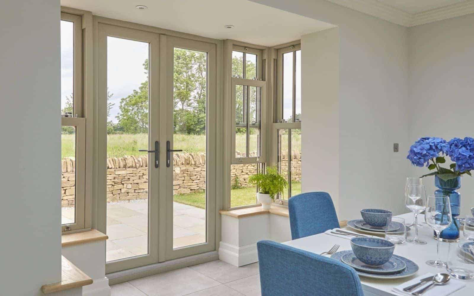 Dining area with blue chairs and Veka Wombleton doors Newmarket - Wymondham Windows